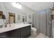 Bright bathroom featuring a large mirror, a dark wood vanity and a shower-tub combo at 10746 W Desert Elm Ln, Peoria, AZ 85383