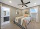 Comfortable bedroom with ceiling fan, light gray walls, and an attached bathroom at 10746 W Desert Elm Ln, Peoria, AZ 85383
