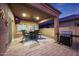 Stylish covered patio with a ceiling fan, outdoor seating, TV, and a built-in grill for entertaining at 10746 W Desert Elm Ln, Peoria, AZ 85383