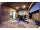 Stylish covered patio with a ceiling fan, outdoor seating, TV, and a built-in grill for entertaining at 10746 W Desert Elm Ln, Peoria, AZ 85383