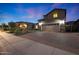 Well-lit home featuring a brick driveway, meticulously arranged landscaping, and a spacious garage at 10746 W Desert Elm Ln, Peoria, AZ 85383