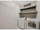 Laundry room featuring modern washer, dryer, and rustic shelving at 10746 W Desert Elm Ln, Peoria, AZ 85383