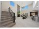 Spacious living room features a stone fireplace, large windows, and a staircase to the second floor at 10746 W Desert Elm Ln, Peoria, AZ 85383