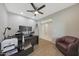Modern office with a ceiling fan, wood-look flooring, and a comfortable armchair at 10746 W Desert Elm Ln, Peoria, AZ 85383