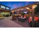 Inviting outdoor living space with a pergola, string lights, and comfortable seating around a fire pit at 10746 W Desert Elm Ln, Peoria, AZ 85383
