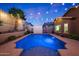 Sparkling swimming pool with accent lighting, set in a private backyard with lush landscaping at 10746 W Desert Elm Ln, Peoria, AZ 85383