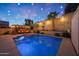 Sparkling swimming pool with accent lighting, set in a private backyard with lush landscaping at 10746 W Desert Elm Ln, Peoria, AZ 85383
