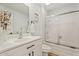 Bright bathroom with modern vanity, framed mirror, and walk-in shower with sliding glass door at 10839 W Peoria Ave, Sun City, AZ 85351