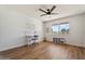Light and airy bedroom featuring a ceiling fan, wood-style flooring, and a bright window at 10839 W Peoria Ave, Sun City, AZ 85351