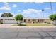 Charming single-story home with well-maintained front yard, mature trees, and convenient two-car garage at 10839 W Peoria Ave, Sun City, AZ 85351