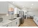 Modern kitchen features stainless steel appliances, white cabinets, marbled countertops, and opens to dining area at 10839 W Peoria Ave, Sun City, AZ 85351