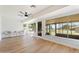 Bright sunroom with wood floors, ceiling fan, and a wall of windows showcasing the backyard at 10839 W Peoria Ave, Sun City, AZ 85351