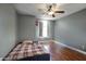 Neutral secondary bedroom with hardwood floors, a ceiling fan, and a large window at 1117 W Manor St, Chandler, AZ 85224