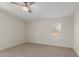 This carpeted bedroom features neutral walls and a ceiling fan at 11912 N Thunderbird Rd, Maricopa, AZ 85139
