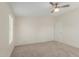 This carpeted bedroom features neutral walls and a ceiling fan at 11912 N Thunderbird Rd, Maricopa, AZ 85139