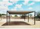 A metal carport structure stands on a wide open fenced property, offering vehicle protection at 11912 N Thunderbird Rd, Maricopa, AZ 85139