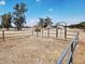 A metal gated fenced-in yard, offering security, with a ranch house in the background at 11912 N Thunderbird Rd, Maricopa, AZ 85139