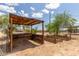 Established garden boxes with an overhead shade structure offer a perfect space for gardening enthusiasts at 11912 N Thunderbird Rd, Maricopa, AZ 85139