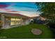 Spacious backyard featuring artificial turf, mature landscaping, and a covered patio area at 1344 N Claiborne --, Mesa, AZ 85205
