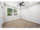 A carpeted bedroom with a ceiling fan and two windows allowing for natural light at 1344 N Claiborne --, Mesa, AZ 85205