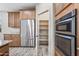 Kitchen featuring stainless steel appliances, including refrigerator, double oven, and a walk-in pantry at 1344 N Claiborne --, Mesa, AZ 85205