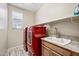 Laundry room with wood-look tile flooring, a sink, shelving, and a red washer and dryer set at 1344 N Claiborne --, Mesa, AZ 85205