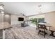 Open-concept living room with wood-look floors, ceiling fan, and backyard view at 1344 N Claiborne --, Mesa, AZ 85205