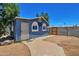 Charming backyard featuring a quaint blue outbuilding, walkway, and secure fencing at 13913 N 2Nd Ave, El Mirage, AZ 85335
