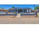Charming single-story home with a blue exterior, solar panels, and a secure fenced yard at 13913 N 2Nd Ave, El Mirage, AZ 85335