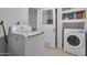 Bright laundry room featuring modern washer, dryer, shelving, and tile floors at 13913 N 2Nd Ave, El Mirage, AZ 85335