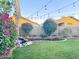 Inviting backyard with a well-maintained lawn, decorative brick border, a charming rock feature, and festive string lights at 1463 E Silver Creek Rd, Gilbert, AZ 85296