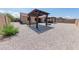 This backyard features a patio cover, built-in barbecue, neutral gravel, and a fenced perimeter for a private outdoor space at 15248 S 182Nd Ln, Goodyear, AZ 85338