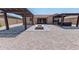 This backyard features a patio cover, built-in barbecue, neutral gravel, a tiled pad and a fire pit at 15248 S 182Nd Ln, Goodyear, AZ 85338
