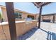 This backyard features a patio cover, a built-in stainless steel barbecue, with brick pavers and neutral gravel at 15248 S 182Nd Ln, Goodyear, AZ 85338