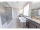 Luxurious bathroom featuring a soaking tub, glass shower, dual vanities, and modern finishes at 15248 S 182Nd Ln, Goodyear, AZ 85338