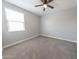 A well-lit bedroom with plush carpet and a modern ceiling fan at 15248 S 182Nd Ln, Goodyear, AZ 85338