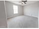 Neutral bedroom with a ceiling fan and a well-lit window overlooking the yard at 15248 S 182Nd Ln, Goodyear, AZ 85338