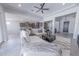 Bright, open-concept living room boasting neutral tile flooring, a modern ceiling fan and ample natural light at 15248 S 182Nd Ln, Goodyear, AZ 85338