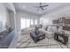 Spacious living room featuring tile floors, a modern ceiling fan, large sliding glass doors, and neutral decor at 15248 S 182Nd Ln, Goodyear, AZ 85338