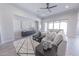 Inviting living room featuring neutral tile flooring, a comfortable couch, modern decor, and ample natural light at 15248 S 182Nd Ln, Goodyear, AZ 85338