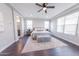 Sun-filled main bedroom features neutral tones, an elegant ceiling fan, and a cozy seating area for relaxation at 15248 S 182Nd Ln, Goodyear, AZ 85338