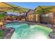 Resort-style backyard pool with rock waterfall, lush landscaping, and shaded lounge areas at 17728 N 92Nd Pl, Scottsdale, AZ 85255