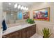 Bright bathroom with a double vanity with marble counter, a walk in shower and artwork at 17728 N 92Nd Pl, Scottsdale, AZ 85255