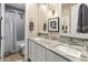 Elegant bathroom with double sinks, granite countertops, and stylish gray herringbone tile in the shower at 17728 N 92Nd Pl, Scottsdale, AZ 85255
