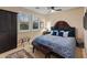 Comfortable bedroom with a paisley-patterned bed, dark wood furniture, and bright, natural light at 17728 N 92Nd Pl, Scottsdale, AZ 85255