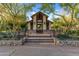 A spacious gazebo with a stone base and decorative metal railing, nestled amongst mature landscaping at 17728 N 92Nd Pl, Scottsdale, AZ 85255