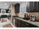 Additional kitchen area featuring dark wood cabinets, stainless appliances, and granite countertops at 17728 N 92Nd Pl, Scottsdale, AZ 85255