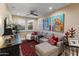Cozy living room featuring a gray sectional, red accents, and unique dog-themed artwork at 17728 N 92Nd Pl, Scottsdale, AZ 85255