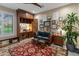 Comfortable living room featuring a custom built in desk, a ceiling fan and a red patterned area rug at 17728 N 92Nd Pl, Scottsdale, AZ 85255