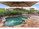 Resort-style pool area features a rock waterfall, lush landscaping, and multiple seating areas at 17728 N 92Nd Pl, Scottsdale, AZ 85255